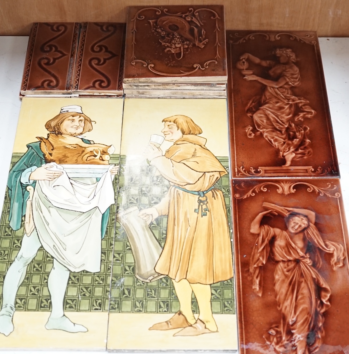 A collection of twelve late 19th/early 20th century glazed earthenware tiles including a pair by Copeland Spode. Condition - fair to good